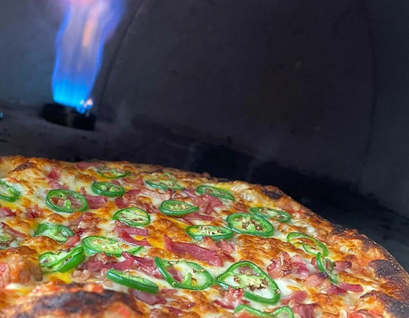 What is the best temperature for cooking pizza in an outdoor pizza oven?